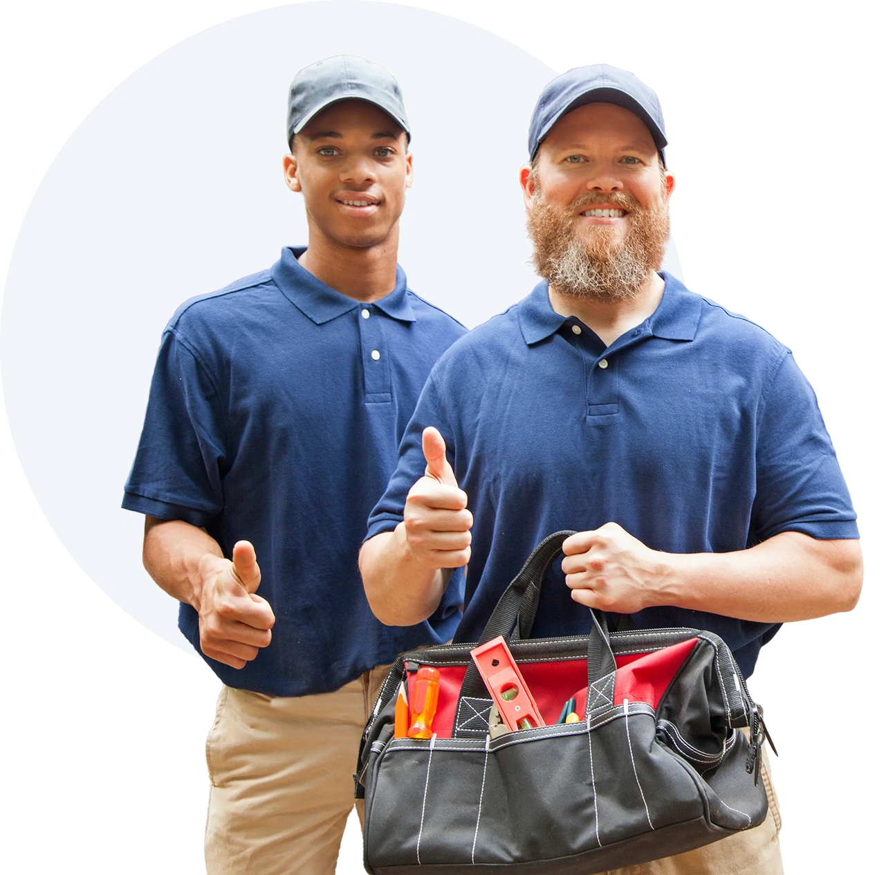 Two men in blue shirts and tan pants, both with smiles on their faces, giving a thumbs up